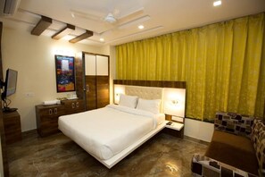 A modern hotel room with a bed, a sofa, a TV, and a desk. - The Cennet Hotel (Ranchi)