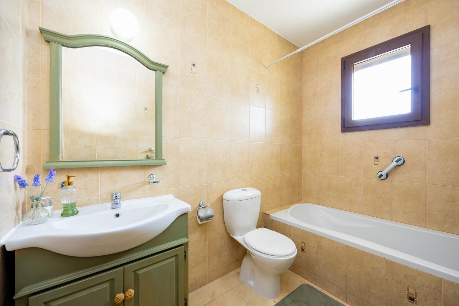 A bathroom with a sink, mirror, toilet, and bathtub.