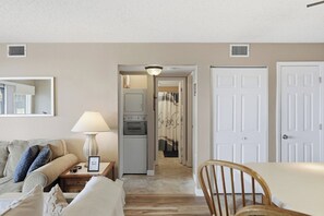 A living room with a sofa, a lamp, a framed picture, and a dining area with a table and chairs. - Southwood Shores 217-1A (Village of Four Seasons)