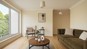 A living room with a round coffee table, a sofa, a chair, a small side table, and a hanging light fixture. - Modern 2-bed Apartment Near Wembley Stadium (Wembley)