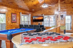 A wooden cabin interior with a pool table, a billiards table, and a table game setup. - Amazing 5BD Lodge w/ VIEWS! Hot Tub + Game/Theater (Sevierville)