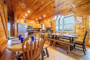 A wooden cabin with a kitchen, dining area, and large windows. - Amazing 5BD Lodge w/ VIEWS! Hot Tub + Game/Theater (Sevierville)