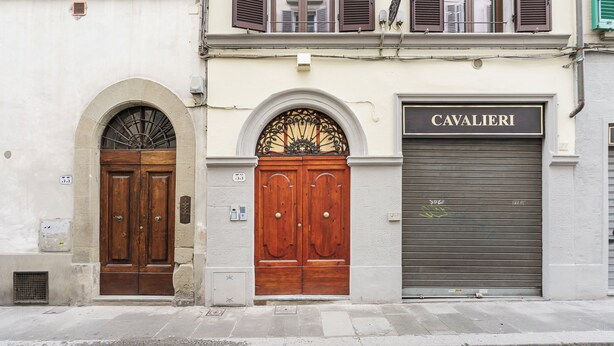 A building with two wooden doors and a garage door labeled "CAVALIERI". - Palazzo Accademia-Beato Angelico-2 (Firenze)