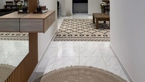 Um interior moderno com um espaço aberto central, detalhes em madeira e um tapete estampado.