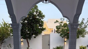 Uma galeria coberta com tapete estampado, que conduz a uma porta.