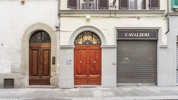 Ein Gebäude mit zwei Holztüren und einer Garage mit der Aufschrift 'CAVALIERI'.