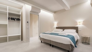 Ein Schlafzimmer mit Bett, Nachttischlampen und einem begehbaren Kleiderschrank.