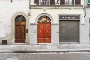 Een gevel met twee houten deuren en een garagepoort met de tekst 'CAVALIERI'.
