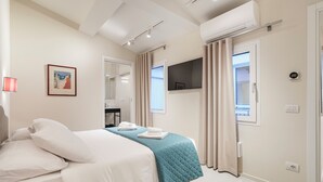 A modern hotel room with a bed, a mirror, a TV, and a window with curtains. - Palazzo Accademia-Michelangelo-5 (Firenze)