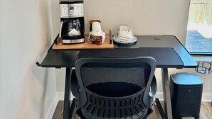 Een moderne keuken met een koffiezetapparaat, een kom ontbijtgranen en een bord eten op een houten tafel.