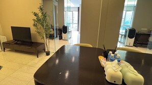 A modern conference room with a large table, chairs, a plant, and a television. - Dorsett Hartamas|KL City|Rooftop Pool|Bathtub|1KM from 1Mont Kiara|8KM from KLCC (Kuala Lumpur)