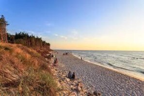 A beach with a rocky shoreline, trees, and a clear sky. - Holiday home, 4 bedrooms, private garden (Debina)