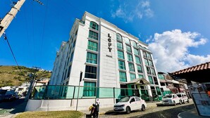 A multi-story building with a prominent 'LOFT' sign, large windows, and a paved entrance area. - Loft equipado a poucos passos da praia (Arraial do Cabo)