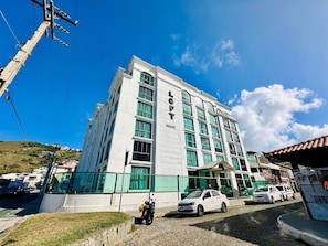 A multi-story building with a prominent 'LOFT' sign, large windows, and a paved entrance area. - Loft equipado a poucos passos da praia (Arraial do Cabo)