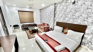 A hotel room with a bed, a sofa, a desk, and a television. - Hotel Siam International Karol Bagh New Delhi (New Delhi)