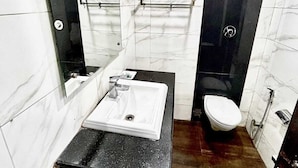 A bathroom with a white sink, black countertop, and a toilet. - Hotel Siam International Karol Bagh New Delhi (New Delhi)
