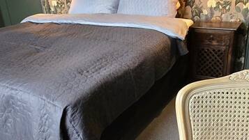 Un dormitorio con una cama, una mesita de noche y una silla.