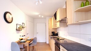 Eine moderne Küche mit Holzausstattung, einer schwarzen Arbeitsplatte und einem Essbereich mit Stühlen und Tisch.