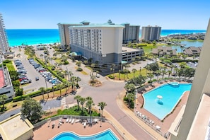 Un resort con piscina, estacionamiento y vista al océano.