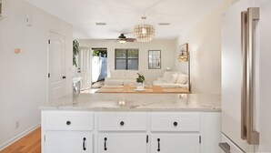 A modern kitchen with white cabinetry, a marble countertop, and a built-in refrigerator. - 2 Bedroom 1.5 Bath Townhouse.  Close to Beach and the Pier/Village area. (Saint Simons Island)