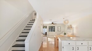A modern kitchen with white cabinets, a marble countertop, and a ceiling fan. - 2 Bedroom 1.5 Bath Townhouse.  Close to Beach and the Pier/Village area. (Saint Simons Island)