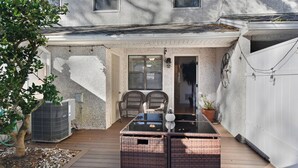 A covered patio with a glass-top table, wicker furniture, and a potted plant. - 2 Bedroom 1.5 Bath Townhouse.  Close to Beach and the Pier/Village area. (Saint Simons Island)