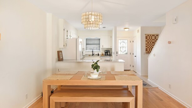 A modern kitchen with white cabinets, a central island, and a hanging light fixture. - 2 Bedroom 1.5 Bath Townhouse.  Close to Beach and the Pier/Village area. (Saint Simons Island)