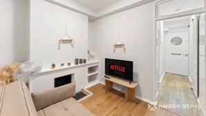 Una sala moderna con un televisor de pantalla plana, una chimenea y una puerta que da a otra habitación.