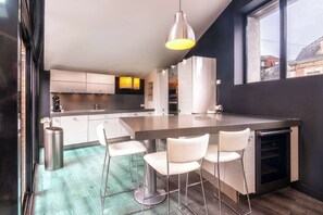 Une cuisine moderne dotée d’un îlot central, de tabourets de bar et d’une grande fenêtre.