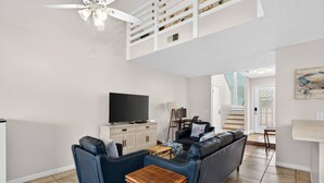 A modern living room with a sofa set, a television, and a ceiling fan. - Emerald Escape 1 - 3 Blocks to Beach (Panama City)