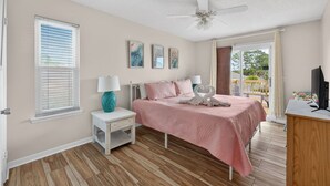 A bedroom with a bed, a nightstand, a ceiling fan, and a TV. - Emerald Escape 1 - 3 Blocks to Beach (Panama City)