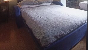 Une chambre à coucher comprenant un lit, une table de chevet, une lampe et un luminaire fixé au mur.