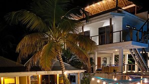 A two-story house with a swimming pool, wooden deck, and a covered outdoor seating area.