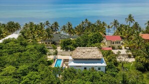 A tropical resort with a pool, palm trees, and ocean views.