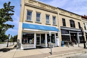 A corner building with a blue awning, a storefront named 'Corner Drugs', and a 'Cellar 159' establishment across the street. - Mainstay in Elk Rapids, splendid views and comfort (Elk Rapids)