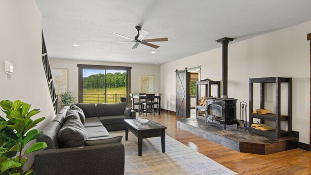 A spacious living area with a sofa, coffee table, and a fireplace. - Wine Country Latitude. Northern Michigan Attitude (Suttons Bay)