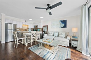 A modern kitchen with white cabinets, stainless steel appliances, and a dining area with a glass table. - 💎Beachfront Luxury 1 BR Condo | 2 Resort Pools | Seaside Beach & Racquet 3205 (Orange Beach)