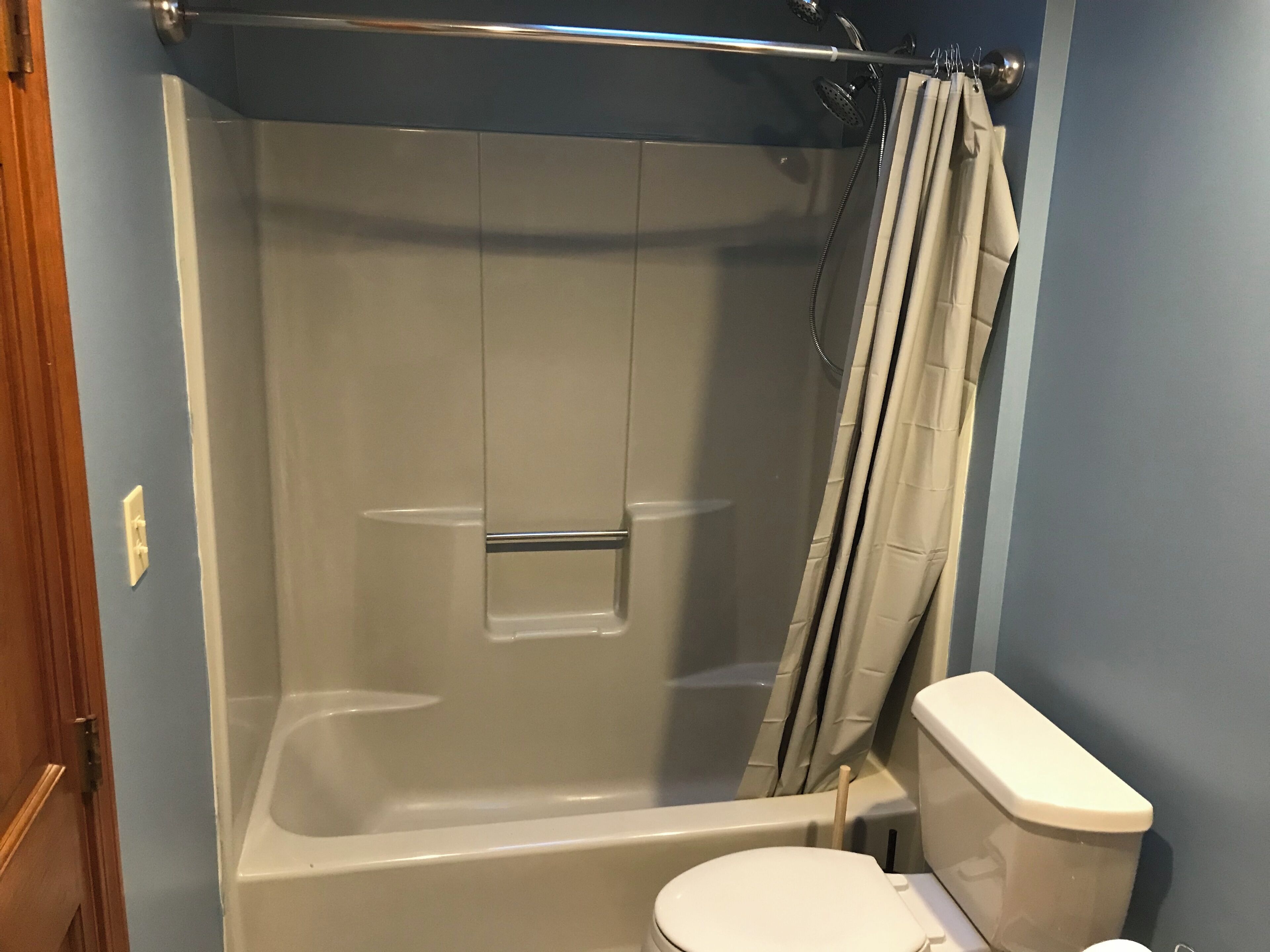 A bathroom with a bathtub, shower, and toilet.
