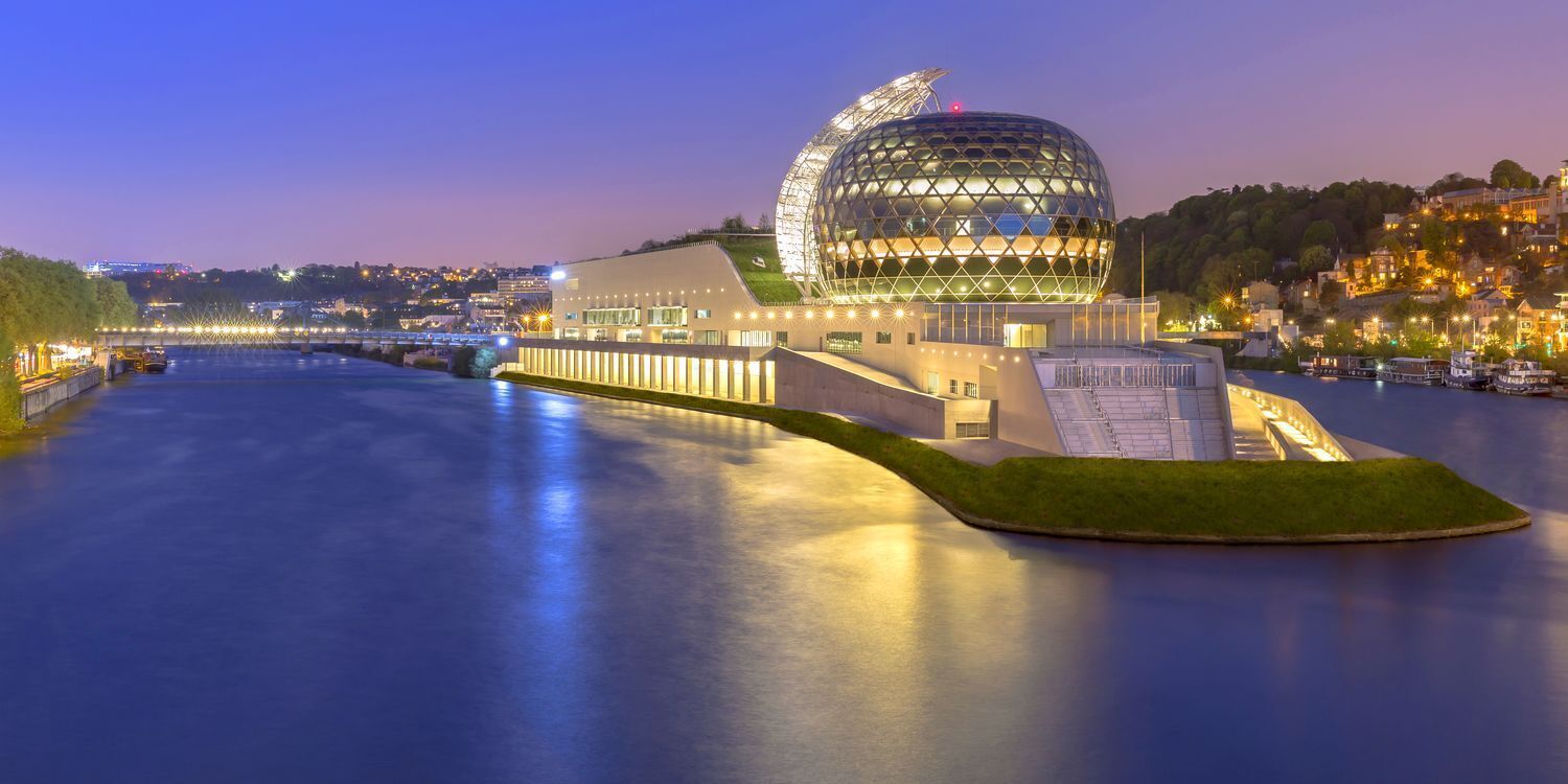 Un bâtiment moderne doté d’une structure sphérique originale et situé en bord de mer.