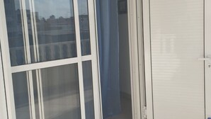 Ett rum med en skjutdörr i glas som leder ut till en balkong.
