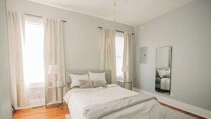 A bedroom with a large bed, bedside tables, a mirror, and curtains. - Modern One bedroom near downtown and Augusta National (Augusta)