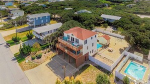 Un quartier résidentiel avec une maison à deux étages dotée d’un balcon, d’une piscine et d’une pelouse bien entretenue.