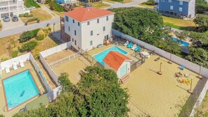 Un quartier résidentiel situé sur la côte, avec un grand immeuble doté d’une piscine et d’une cour arrière clôturée.