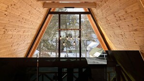 A wooden interior with a triangular skylight and hanging light fixtures. - A frame cabins in the heart of a national park! (Rakovac)