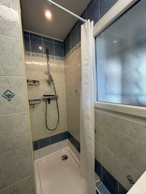 A small, enclosed shower area with a window, tiled walls, and a showerhead. - La Croix du Sud 2 – T2 4 pers proche plage (Le Grau-du-Roi)