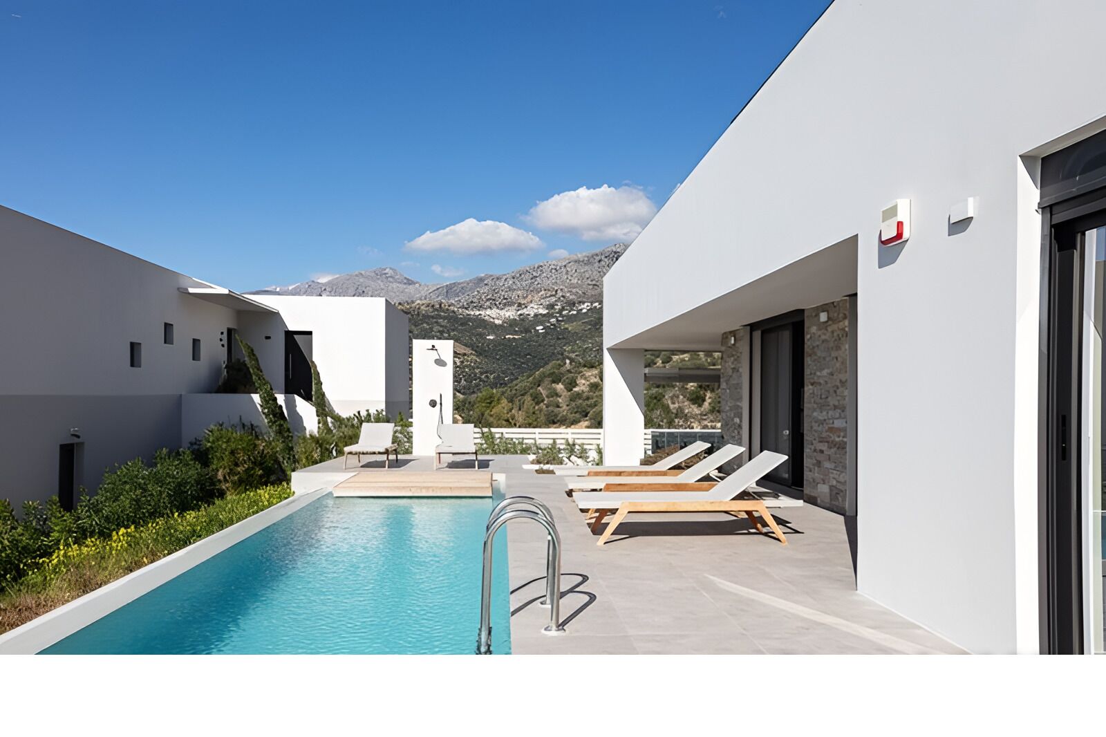 A modern pool area with a clear view of mountains in the background.
