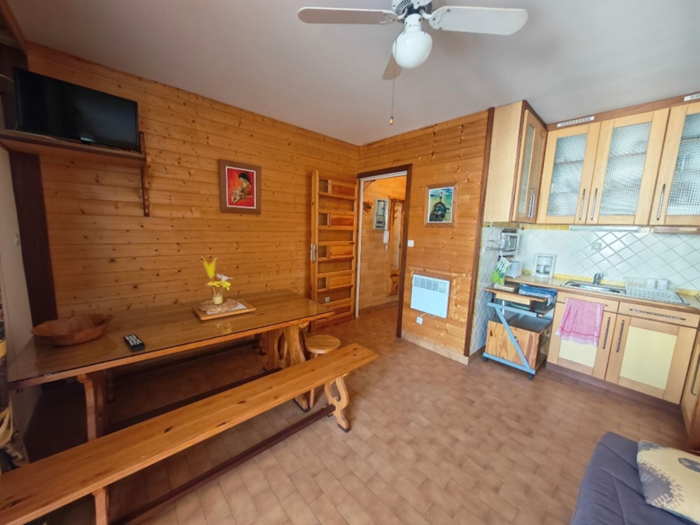 Ein Holzinterieur mit Küchenbereich, einem Esstisch und einer Bank.