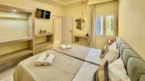Quarto de hotel moderno com duas camas, televisão, espelho e janela com vista para áreas verdes.