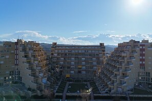 Un edificio residenziale a più piani con cortile interno, balconi e tetto piano.