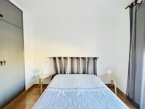 A bedroom with a bed, two bedside tables, a wardrobe, and a curtain. - Spacious apartment in Roses - Quiet area for 5 (Roses)